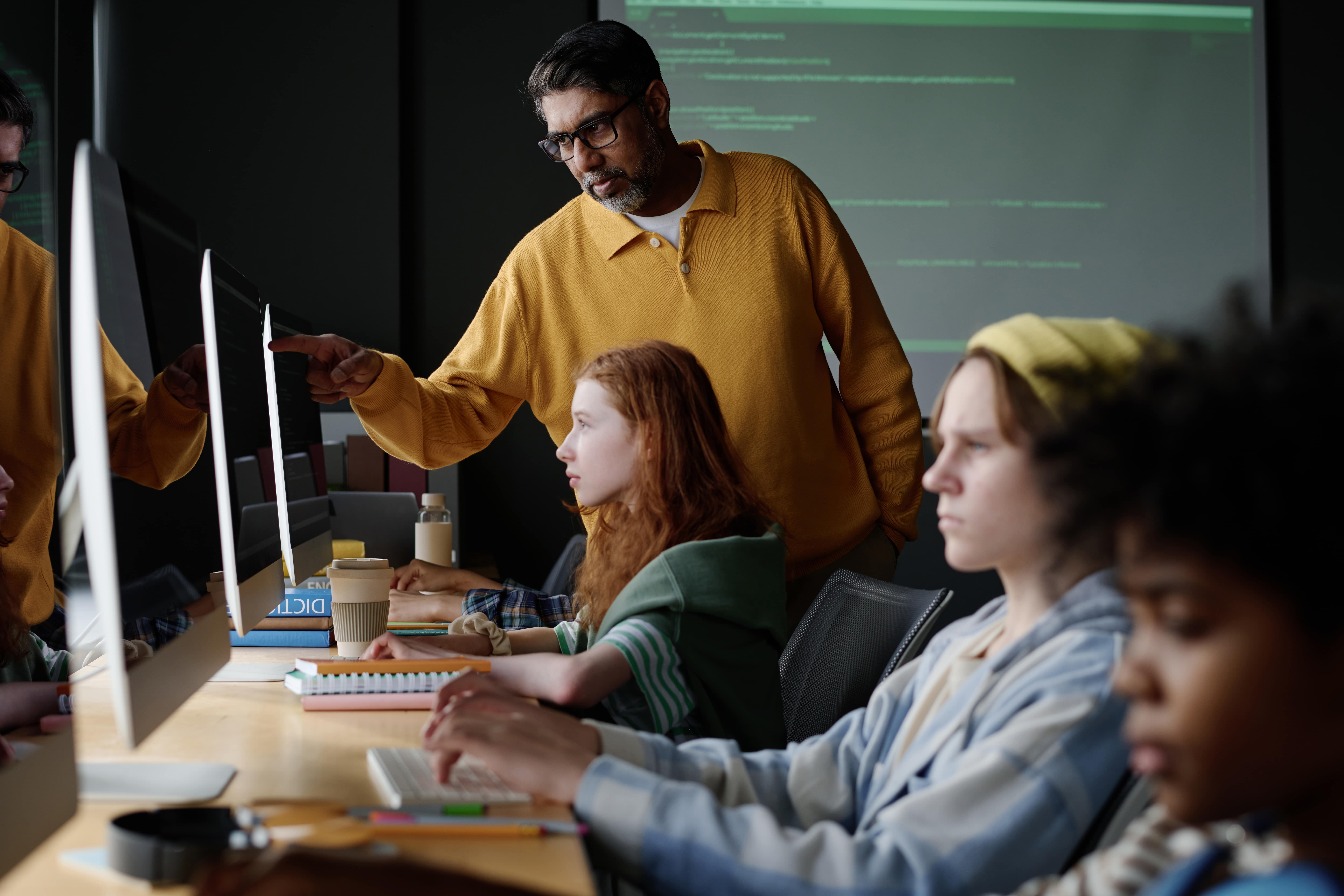 An IT-teacher schooling a class in a computer lab.